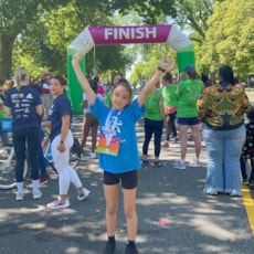 Girls on the Run participant cheers after crossing the finish line